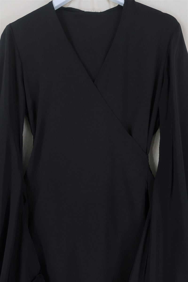Flat lay of our Venus Khroma wrap dress in Vampy Black, a sleek and sultry classic which is easy to style and versatile to wear! Inspired by 70's bohemia by All About Audrey