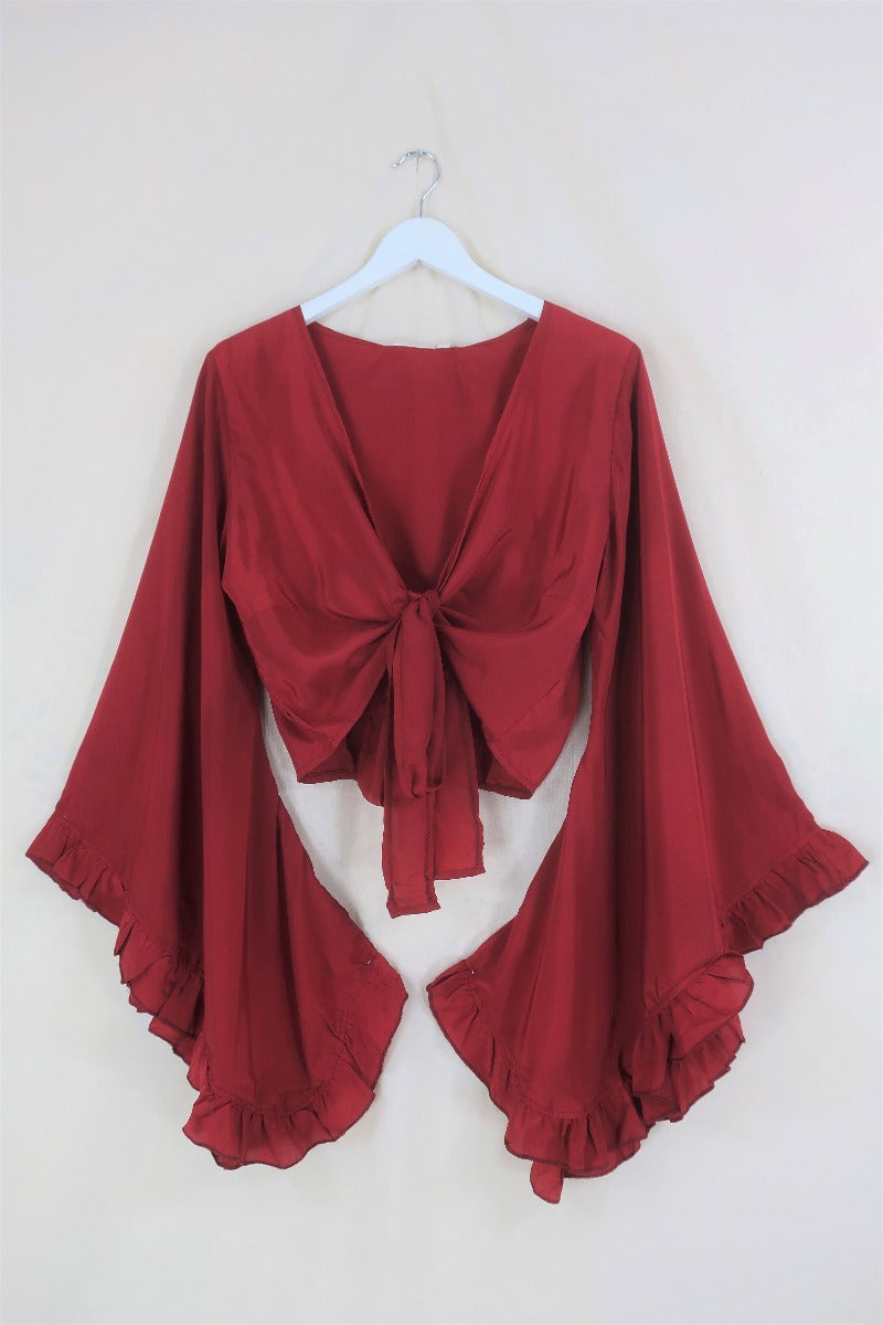 Flat lay of our Venus Khroma wrap top in Scarlet Red, a spicy and bold classic which is easy to style and versatile to wear! Inspired by 70's bohemia by All About Audrey