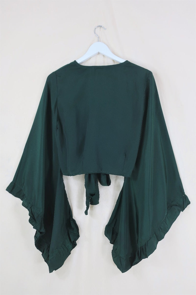 Flat lay of our Venus Khroma wrap top in Golden Sands, a neutral, earthy, antique gold tone which is easy to style and versatile to wear! Inspired by 70's bohemia by All About Audrey