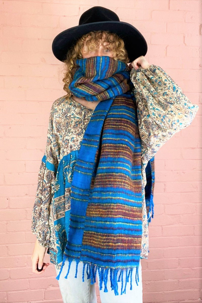 recycled Indina scarf in sapphire blue with red and gold stripes worn wrapped up into a face covering my model - All About Audrey