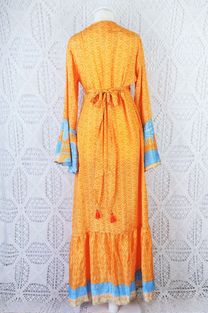 back of aprioct orand and powdered blue boho wrap dress with waist ties tied in a bow