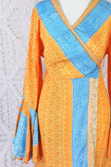 close up on frill sleeve in apricot orange with splashed of powdered blue print