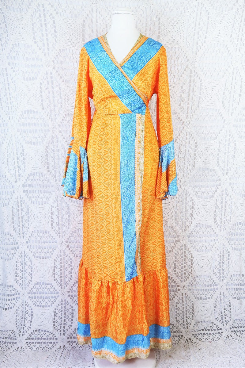 front facing full body shot of boho wrap dress in apricot orange and powdered blue with frill sleeves