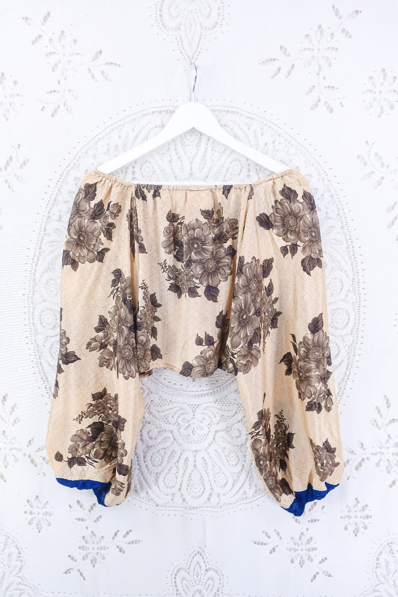 Back view of our Ariel top. This Ariel top is a gorgeous sandy tone with muted brown florals and blue accents on the cuffs. A real beauty for a summery warm day, as well as a great layering piece.