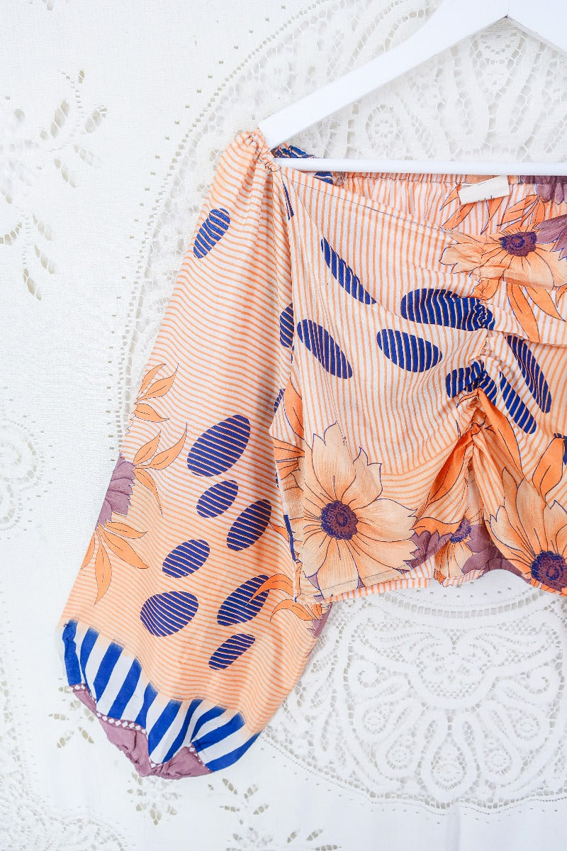 Close up of our Ariel top in Apricot Bubble Stripe. Photo displays the ruched design on the bust, sweetheart neckline and flowy balloon sleeves.