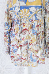 Photo shows close up of mannequin wearing our Daisy cotton smock top in a boho peacock block print design with balloon sleeves and a tie neckline.