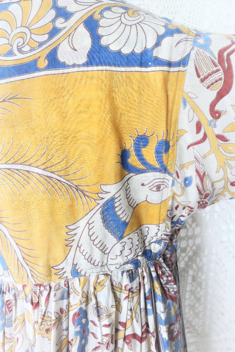 Photo shows a back close up of the mannequin wearing our Daisy cotton smock top in a boho peacock block print design with balloon sleeves and a tie neckline.