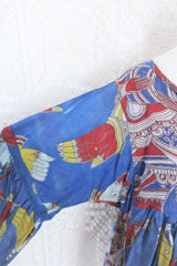 Photo shows close up of a deep blue peacock and hand gesture block printed boho smock top with a tie neck and balloon sleeves.