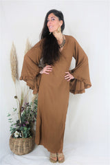 Model wears our bohemian bell sleeve wrap maxi dress in cinnamon brown. Long floaty sleeves with a ruffle hem and a wraparound tie waist to create an elegant shape by all about audrey