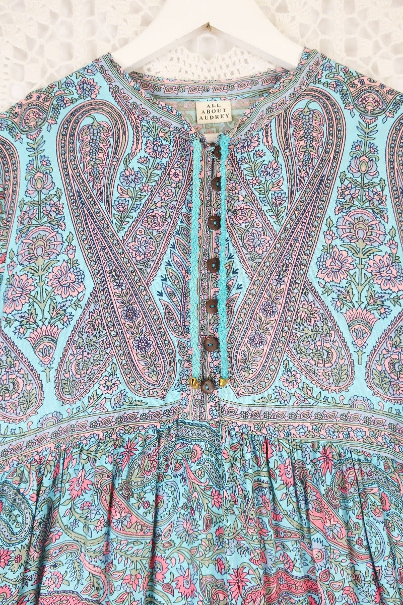 detail image of florence maxi dress yolk showing large contrasting paisley design and button down high neck yolk with rope ties in blue and pink printed sustainable rayon fabric by all about audrey