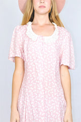 Close up Photo of print and detailing on baby pink bowtie polka dot printed mini shift dress with a lace collar.
