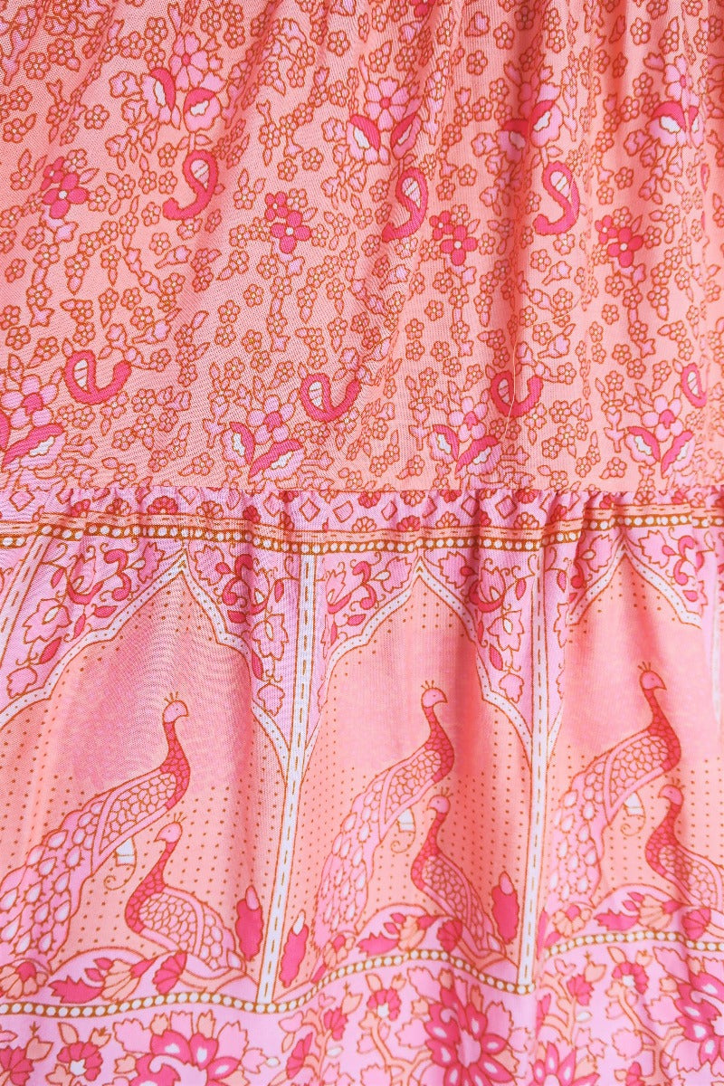 close up detail contrast indian style block printed hemline and tiered cut on peacock prairie bohemian maxi skirt in peachy rose pink rayon by all about audrey