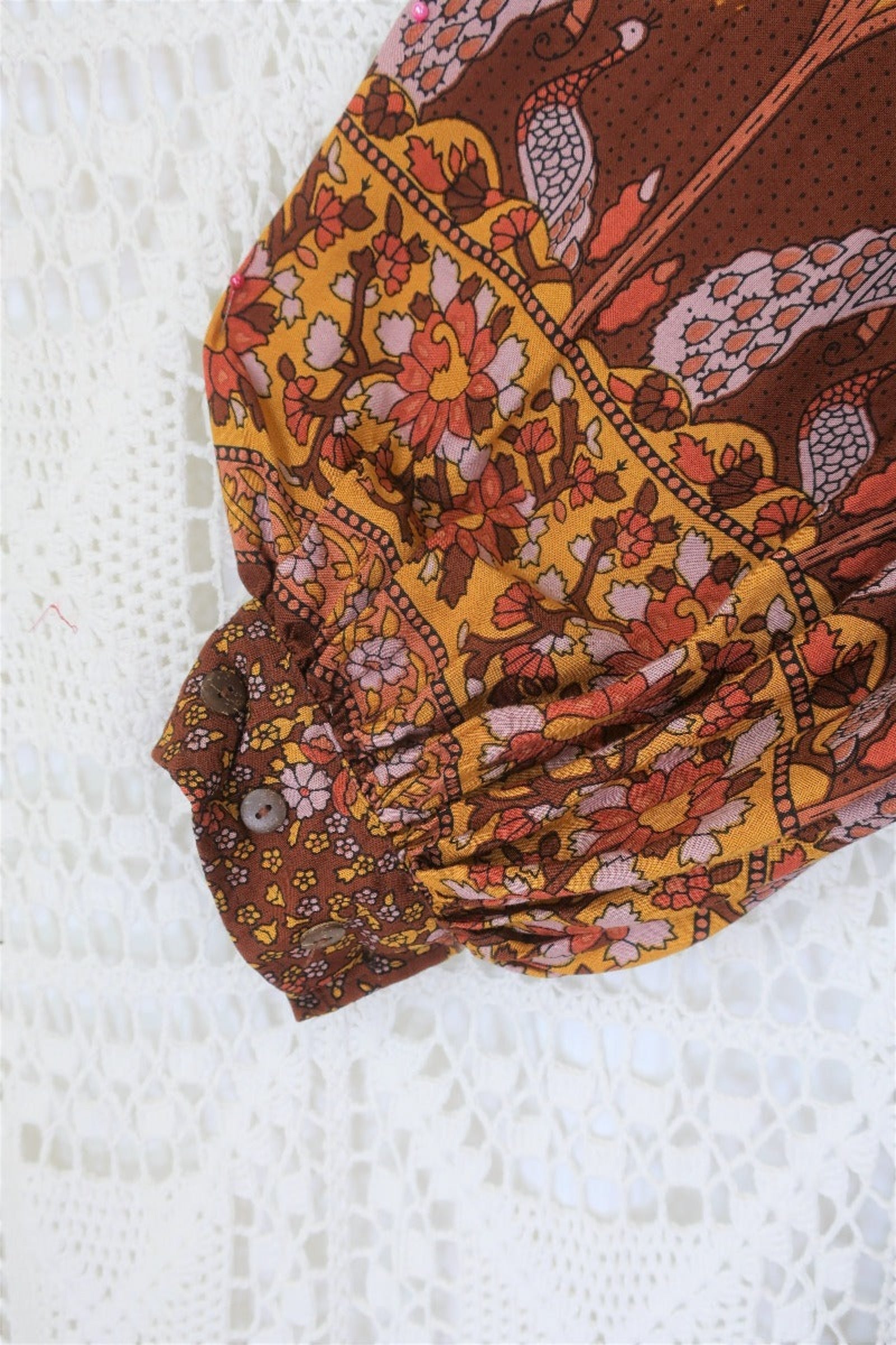 close up sleeve peacock primrose midi dress with balloon sleeves in 70s smocked style indian printed rayon colour gingerbread by all about audrey