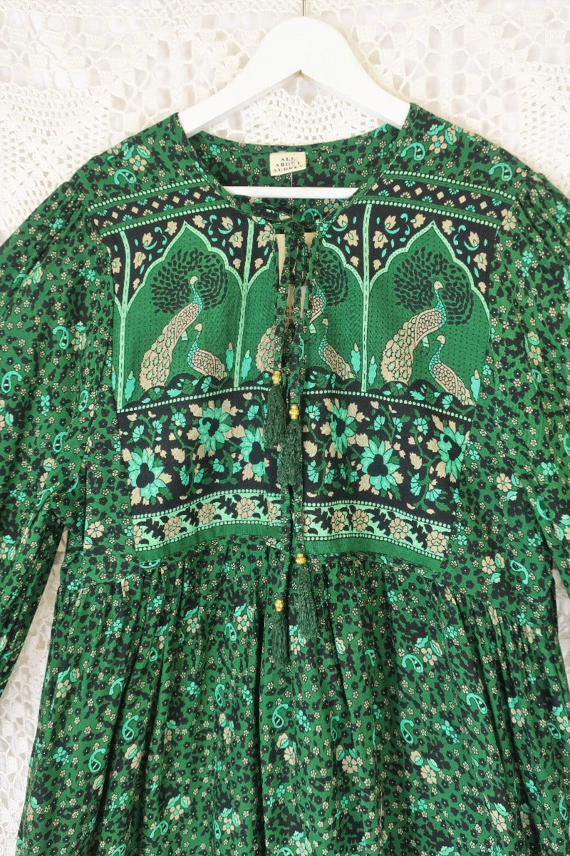 close up of contrast yolk on indian peacock printed primrose midi length dress in forest green with exaggerated balloon sleeve in 1970s vintage inspired bohemian style by all about audrey