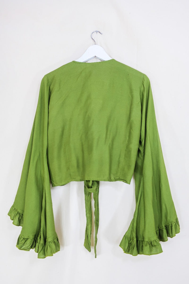 Flatlay of our pixie green khroma venus wrap top by all about audrey