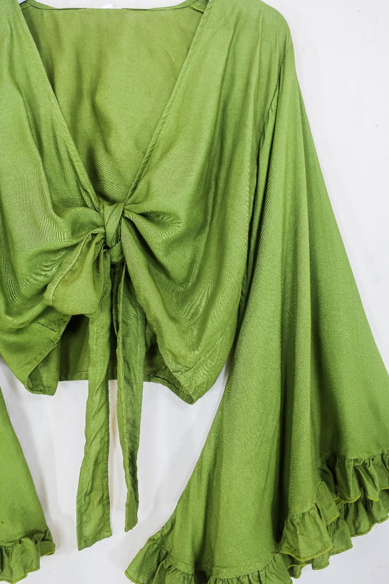 Flatlay of our pixie green khroma venus wrap top by all about audrey