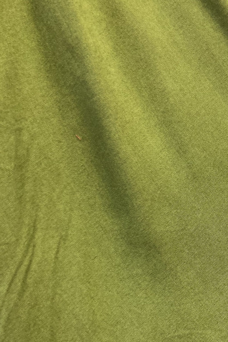 Flatlay of our pixie green khroma venus wrap top by all about audrey