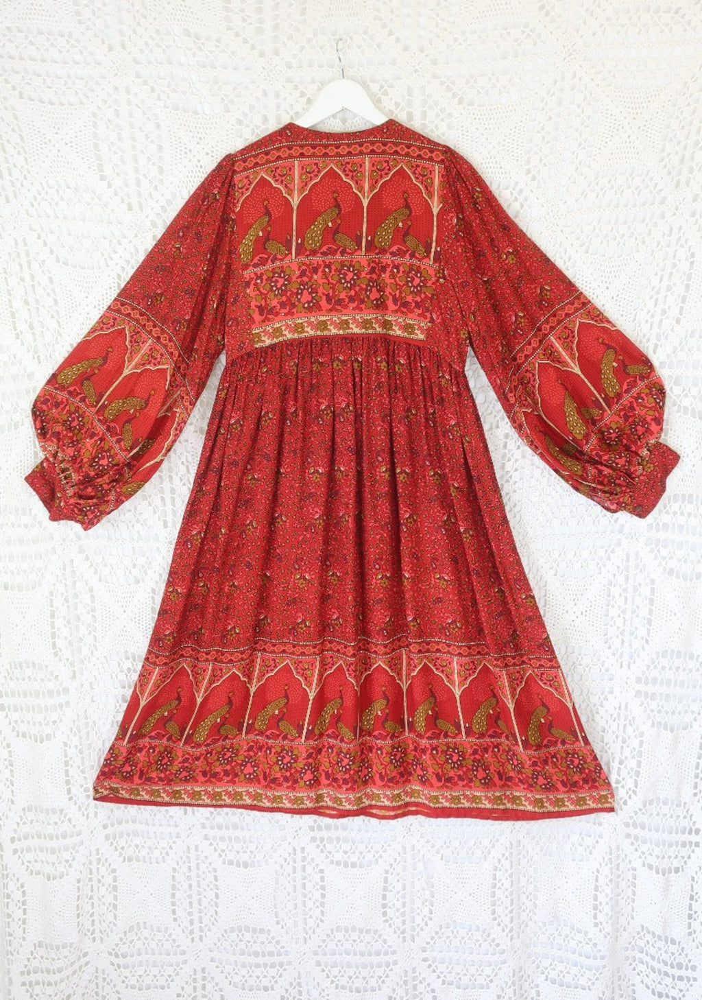 laid flat back view of balloon sleeve smocked style peacock primrose midi dress in berry red with gold detailed vintage inspired indian peacock design from our collection of bohemian dresses by all about audrey