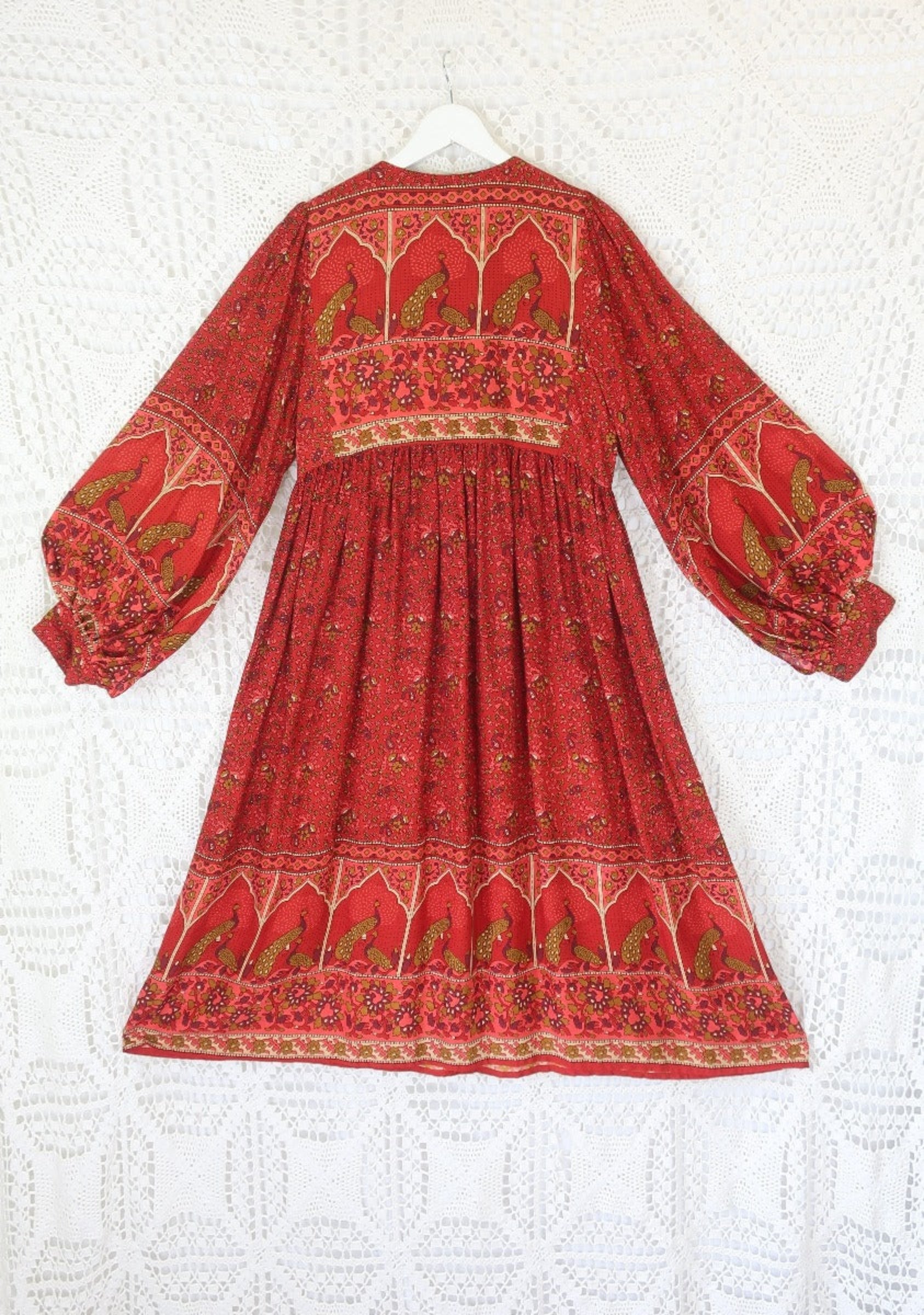 laid flat back view of balloon sleeve smocked style peacock primrose midi dress in berry red with gold detailed vintage inspired indian peacock design from our collection of bohemian dresses by all about audrey