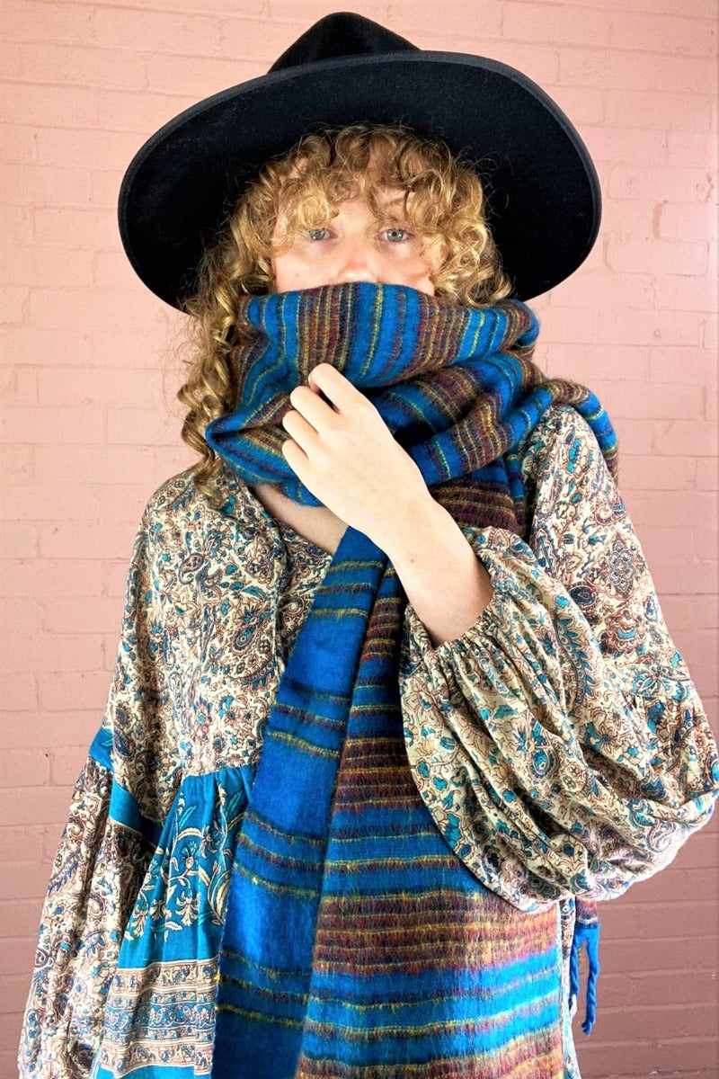 sapphire reversible Indian recycled shawl with ruby & gold stripes, worn wrapped up into a face covering by model - All About Audrey
