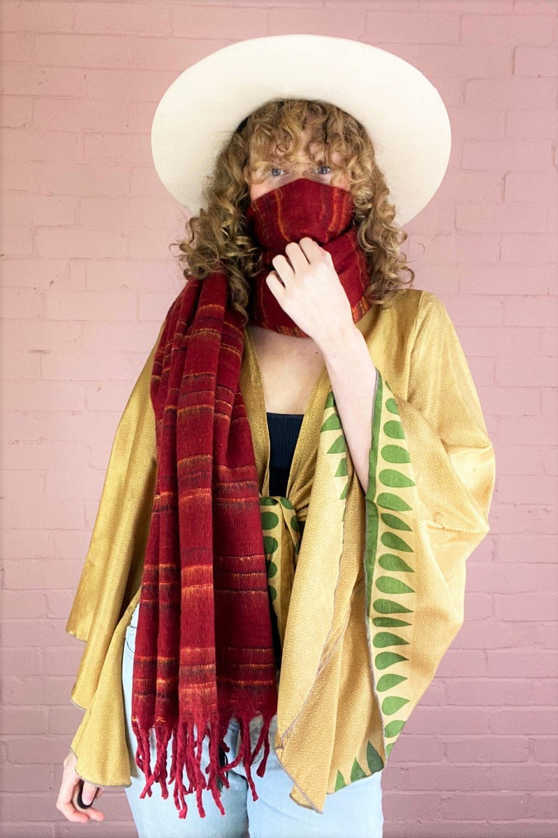 recycled Indian scarf in cherry red, black & yellow reversible stripy print, worn wrapped up into a face covering by model - All About Audrey