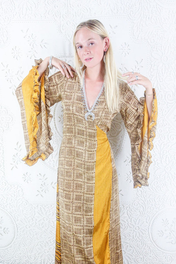 Our Venus Wrap dress in Hickory & Sunflower Yellow. Model shows off the floaty bell sleeve and wrap design. By All About Audrey.