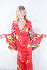 Model shows front view of our Venus maxi wrap dress. Wrap dress design with floaty bell sleeves. By All About Audrey.