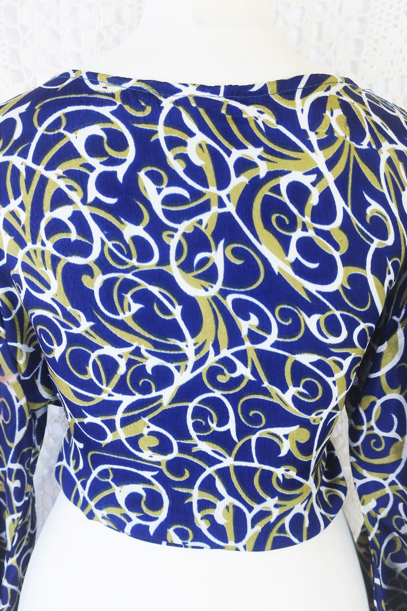 navy blue white and olive green block print with magenta and grey floral borders gemini boho bell sleeve wrap top photographed on a uk size 8 mannequin by all about audrey