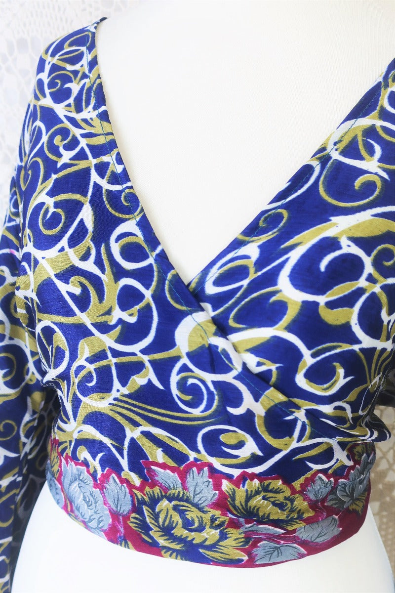 navy blue white and olive green block print with magenta and grey floral borders gemini boho bell sleeve wrap top photographed on a uk size 8 mannequin by all about audrey