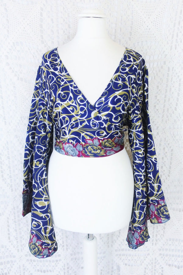 navy blue white and olive green block print with magenta and grey floral borders gemini boho bell sleeve wrap top photographed on a uk size 8 mannequin by all about audrey