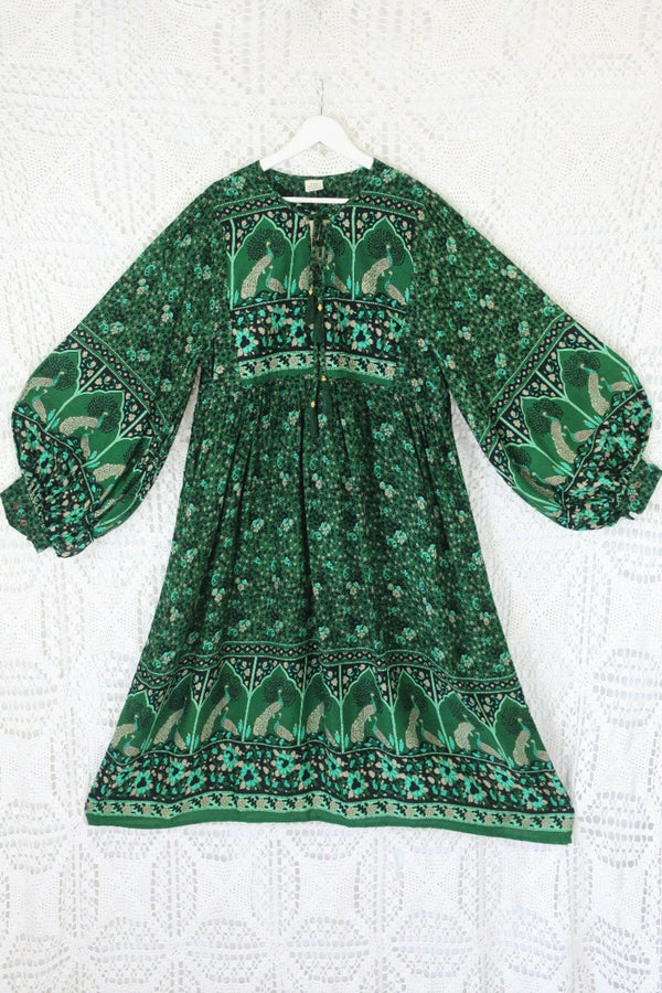front indian peacock printed primrose midi length dress in forest green with exaggerated balloon sleeve in 1970s vintage inspired bohemian style by all about audrey
