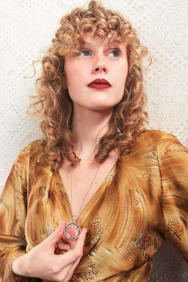 model wears boho pressed flower pendant in gold colour on long chain from our collection of vintage inspired jewellery by all about audrey