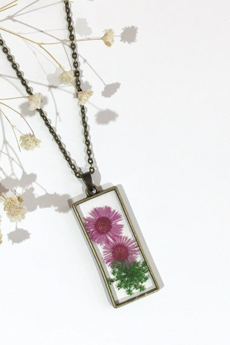 laid flat pink dried flower pendant in brass rectangle shape on chain from our vintage inspired jewellery and gifts collection by all about audrey