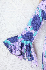 close up on the pinned sleeve of dusky purple and aqua floralprint sylvia boho wrap dress