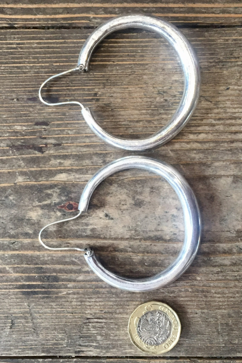 laid flat next to coin to show size large silver painted hoop earrings from our boho jewellery collection at all about audrey