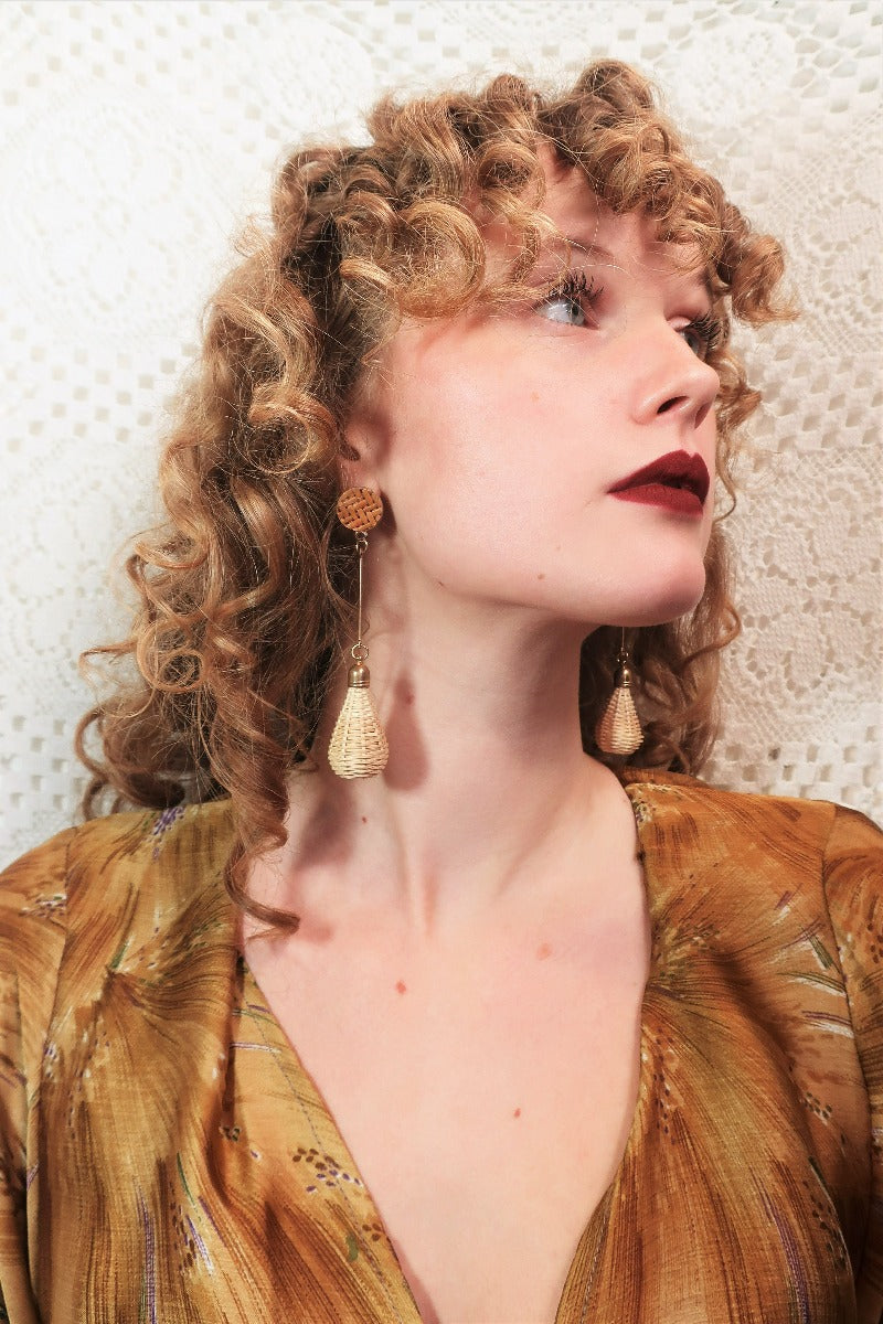 model wears rattan brass earrings with round stud with long bar and teardrop shaped woven pendant from our collection of bohemian accessories and jewellery gift ideas by all about audrey